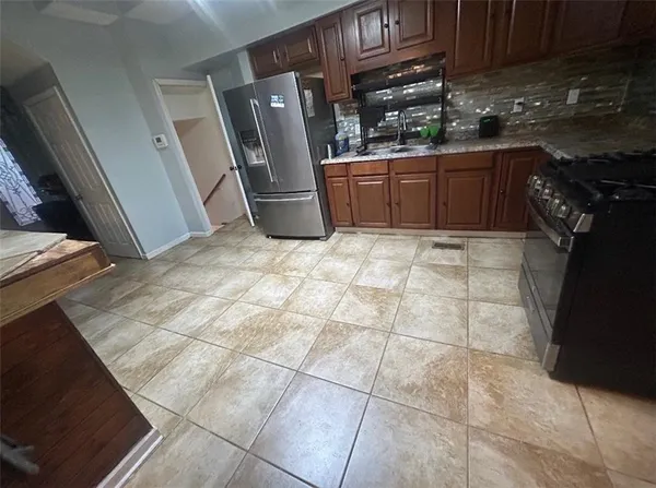 a kitchen with stainless steel appliances granite countertop a refrigerator and a stove