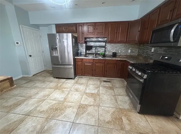 a large kitchen with cabinets and stainless steel appliances