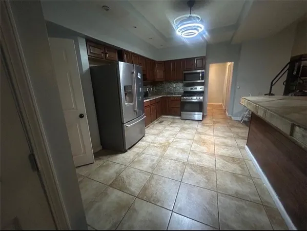 a bedroom with a bed a mirror on dresser and a chandelier