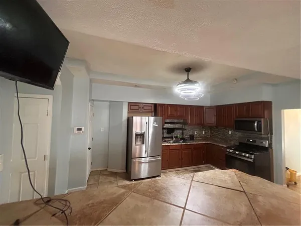 a kitchen with stainless steel appliances granite countertop a refrigerator a sink and a stove