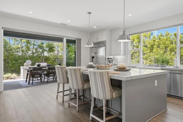 a view of a patio with couches table and chairs with potted plants and wooden fence