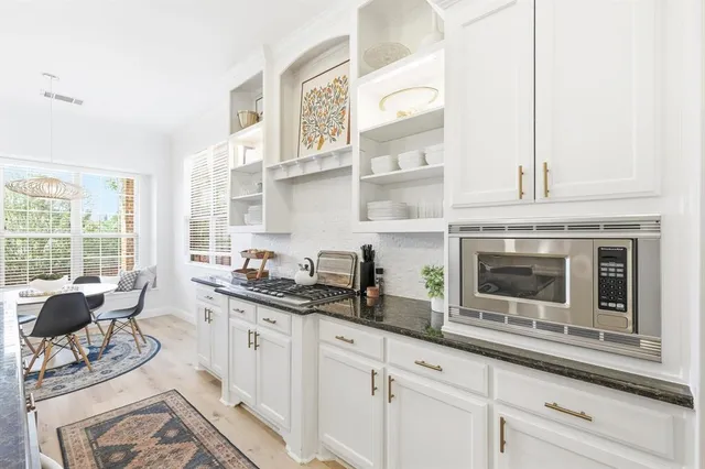 a kitchen with stainless steel appliances granite countertop a sink a stove and cabinets