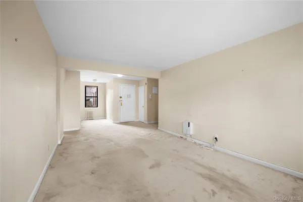 an empty room with white walls and windows