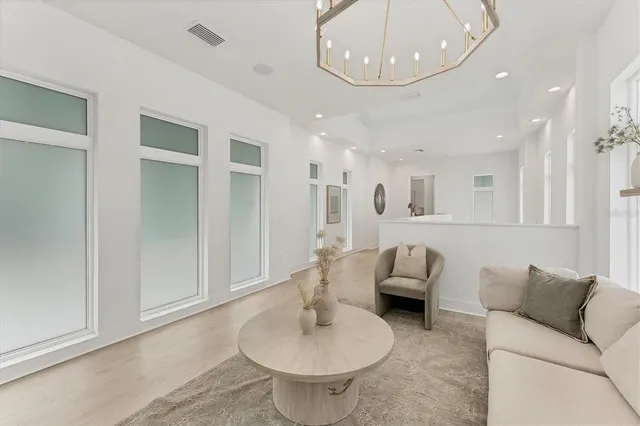 a living room with furniture and a chandelier