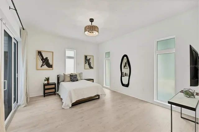 a bedroom with a large bed and a chandelier