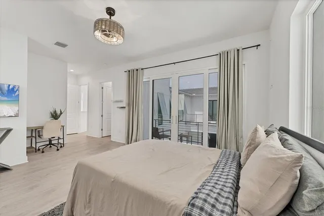 a bedroom with a bed and a chandelier