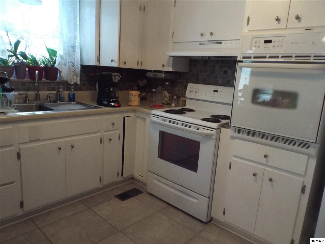 417 New Riverside Drive Sevierville, TN 37862 - Photo 11 of 18 a kitchen with white cabinets and white appliances