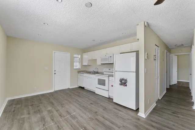 a kitchen with white cabinets and white appliances