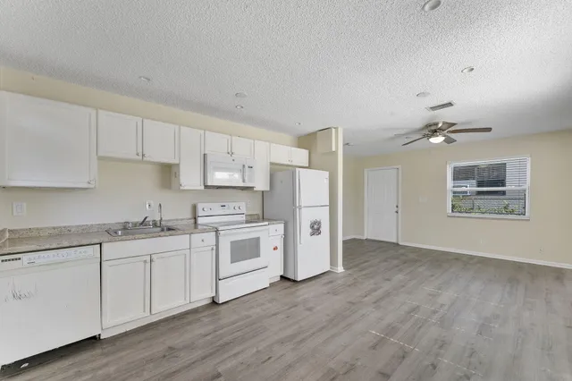 a kitchen with stainless steel appliances a sink cabinets and wooden floor