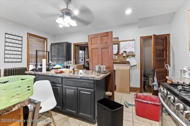 a kitchen with granite countertop a stove a sink and a refrigerator