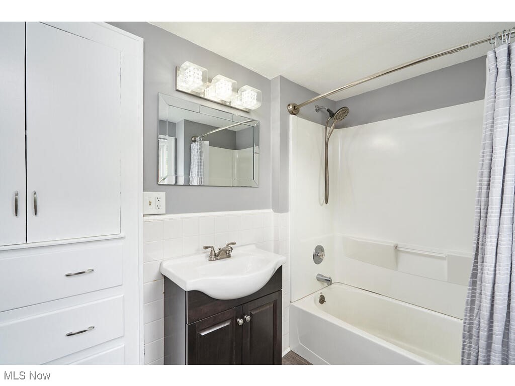 3468 Copley Road Akron, OH 44321 - Photo 15 of 22 Bathroom with shower / tub combo with curtain, vanity, tile walls, and backsplash