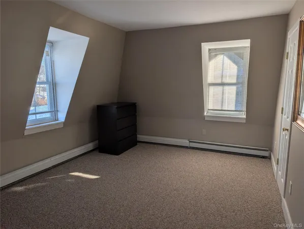 a view of an empty room with closet and a window