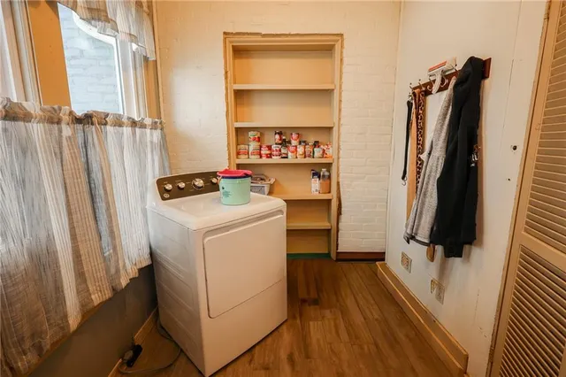 an empty room with wooden floor a ceiling fan and a fireplace