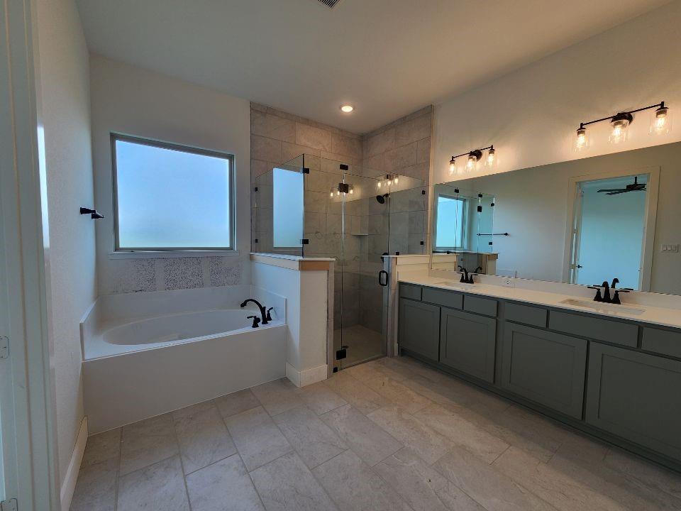 2408 Quartz Street Krum, TX 76249 - Photo 9 of 16 a bathroom with a tub sink double vanity granite tub shower and mirror