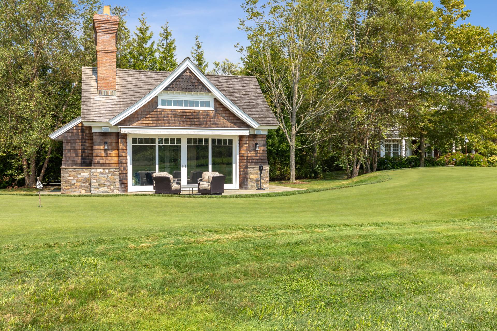461 Ocean Road Bridgehampton, NY 11932 - Photo 23 of 29 a front view of a house with a garden and trees