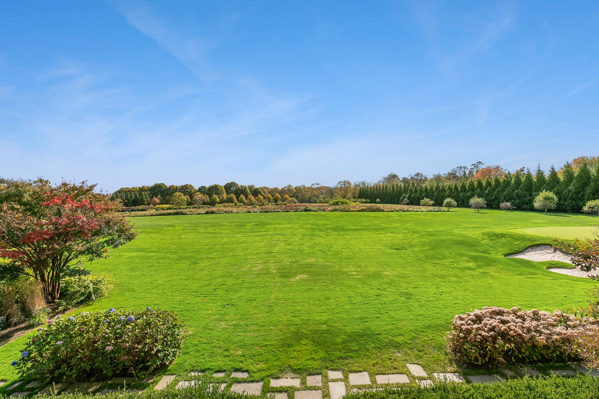 461 Ocean Road Bridgehampton, NY 11932 - Photo 26 of 29 a view of a grassy field with an trees