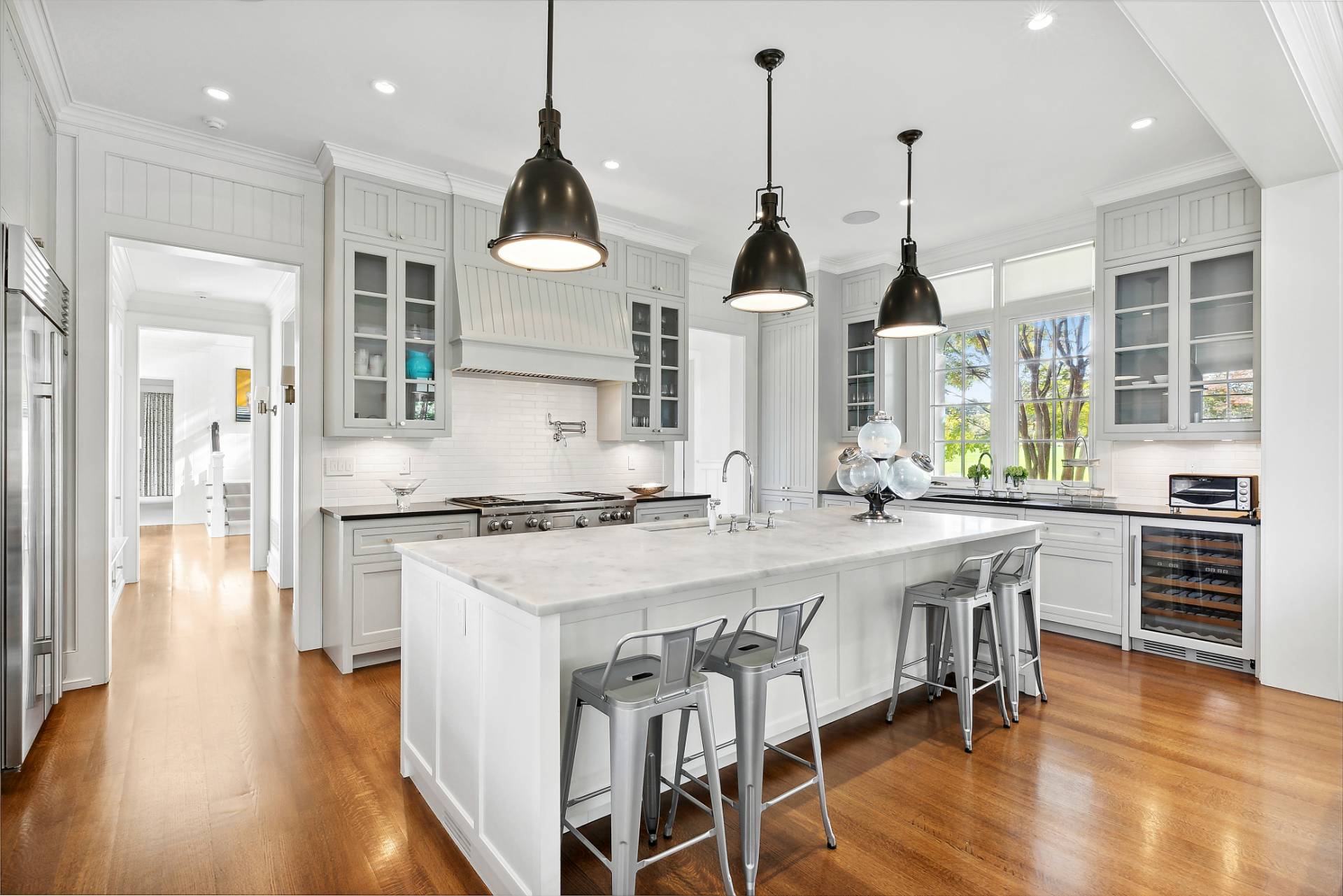 461 Ocean Road Bridgehampton, NY 11932 - Photo 7 of 29 a kitchen with stainless steel appliances a stove a sink a kitchen island with wooden floor and cabinets