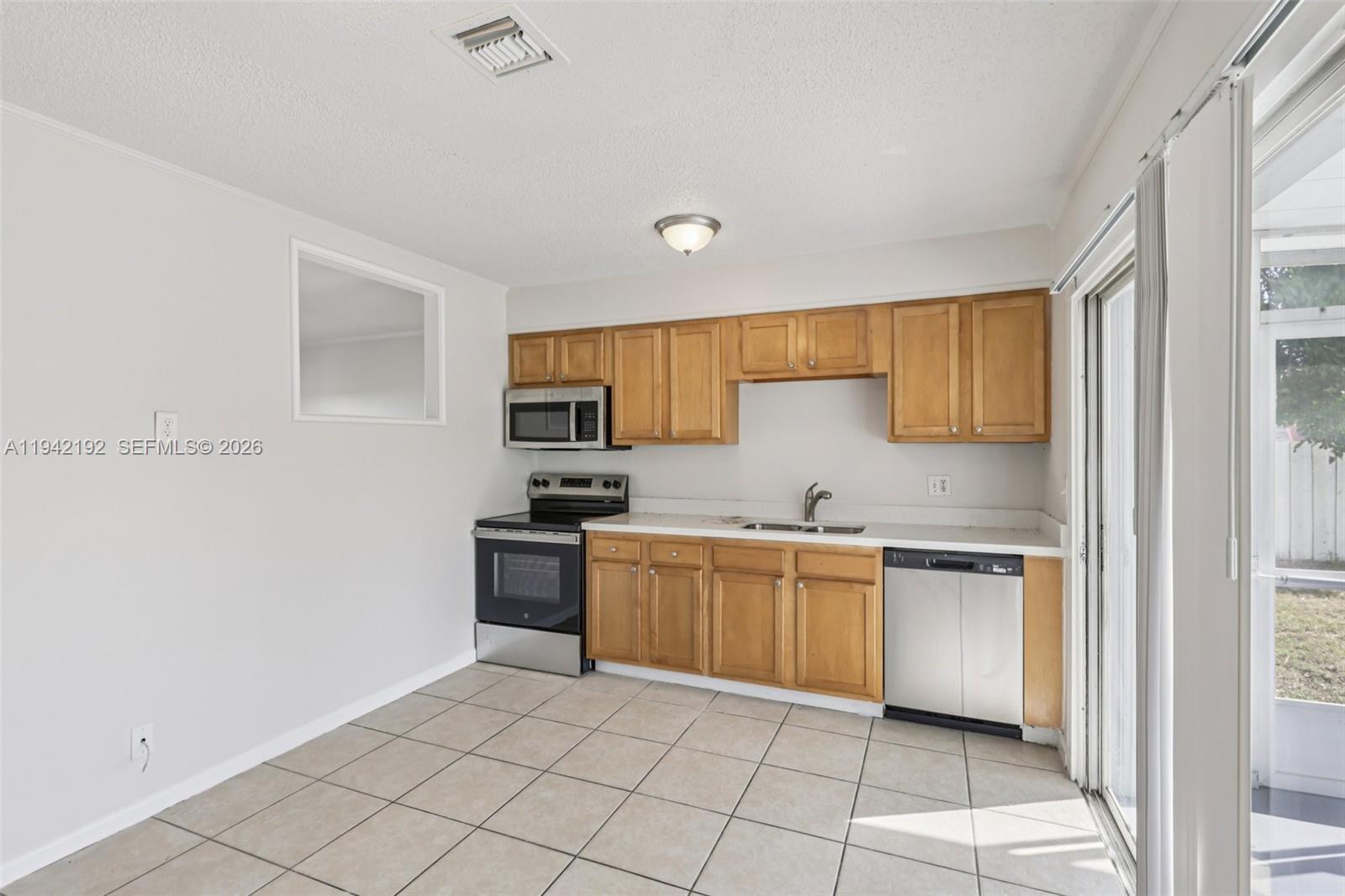 3209 Scanlan Avenue Lake Worth, FL 33461 - Photo 15 of 41 a kitchen with stainless steel appliances granite countertop a stove a sink and a refrigerator