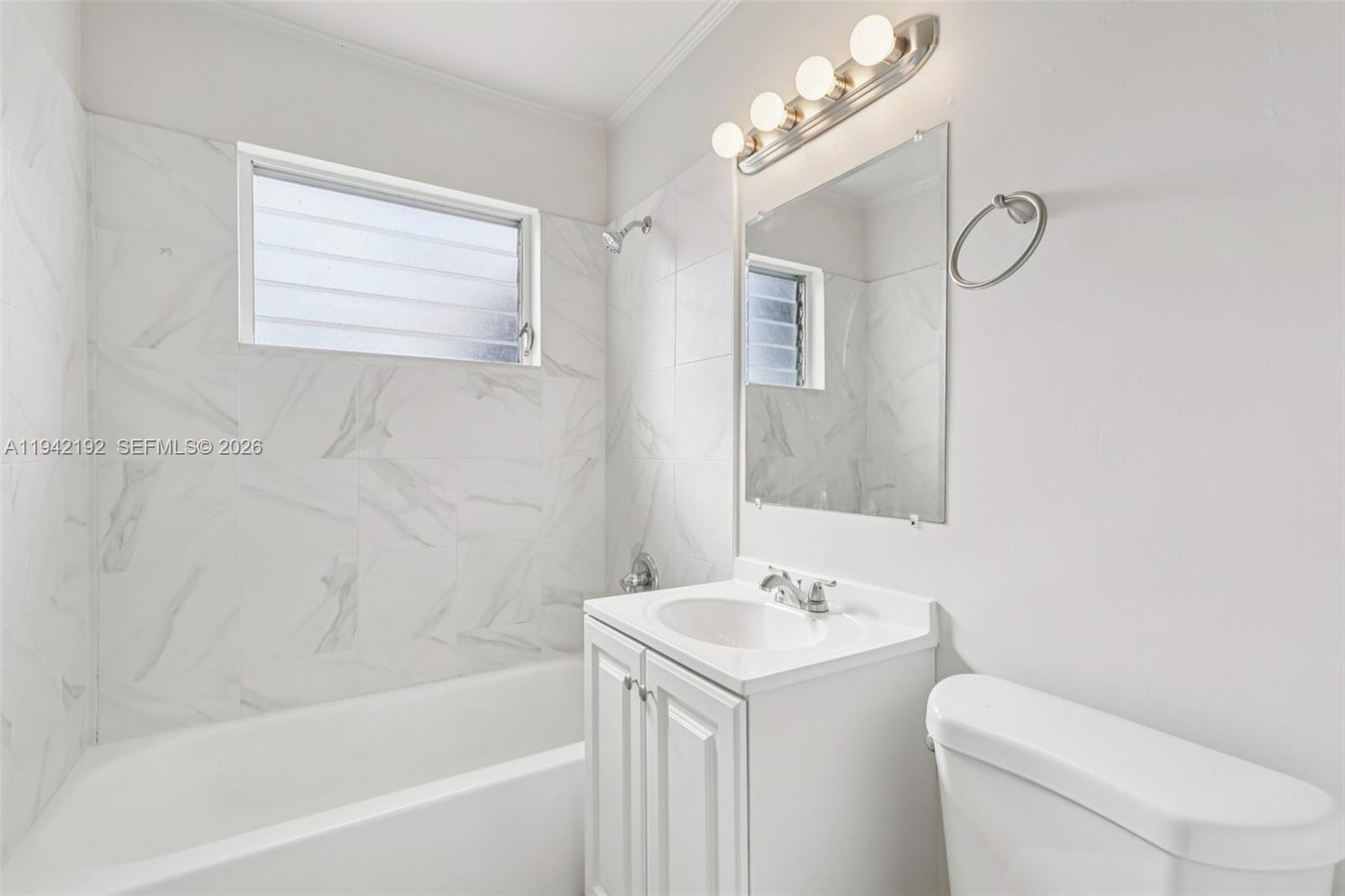 3209 Scanlan Avenue Lake Worth, FL 33461 - Photo 32 of 41 a bathroom with a sink a toilet and a bathtub