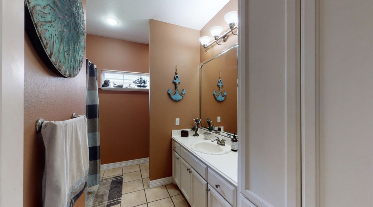 104 Mockingbird Lane Bridge City, TX 77611 - Photo 23 of 27 a bathroom with a sink and mirror
