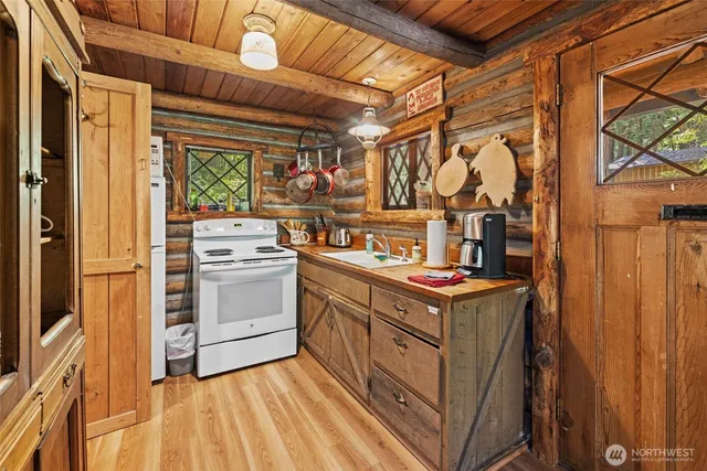 a kitchen with a stove top oven cabinetry and a sink