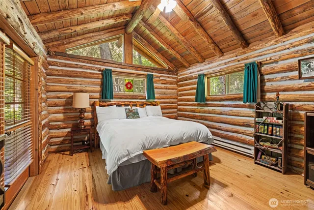 a bedroom with bed and wooden floor