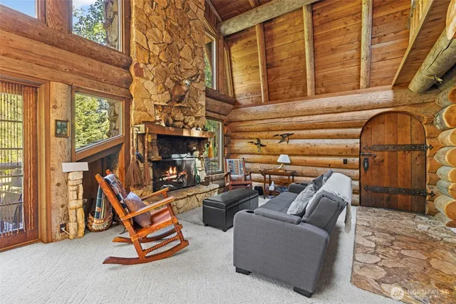 a living room with furniture a fireplace and a floor to ceiling window
