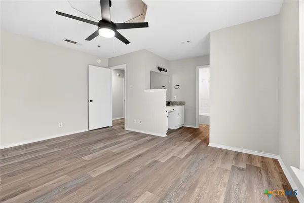 a view of empty room with wooden floor