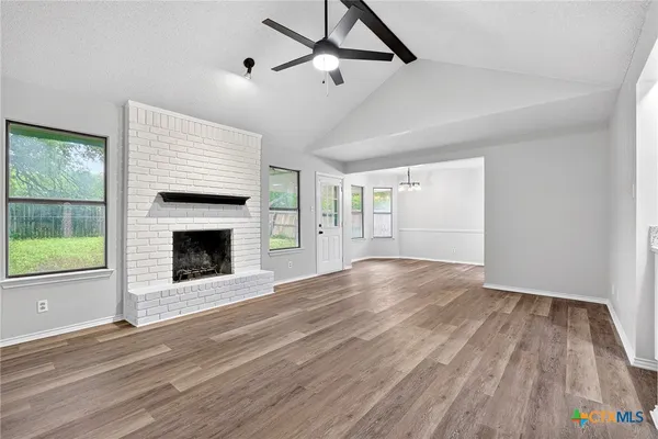 a view of empty room with wooden floor and fireplace