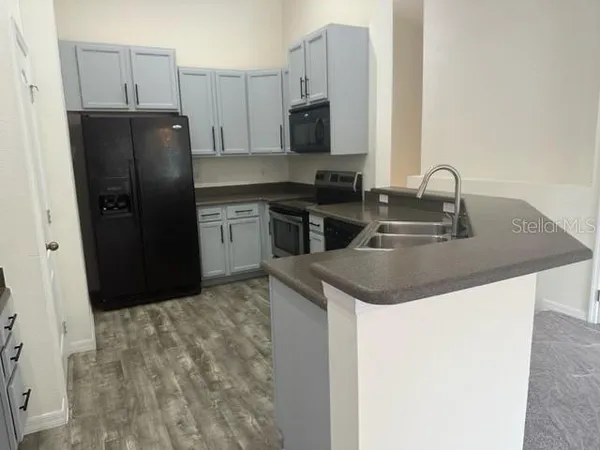 a kitchen with a sink a refrigerator and a stove