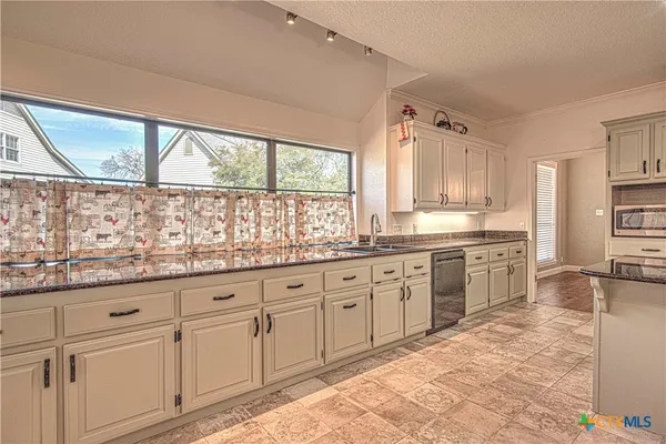 a kitchen with stainless steel appliances kitchen island granite countertop a refrigerator and a stove top oven