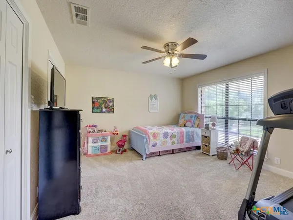 a bedroom with a bed a dresser and window