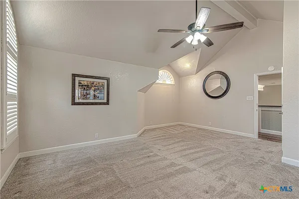 a view of a room with a chandelier fan and wooden floor