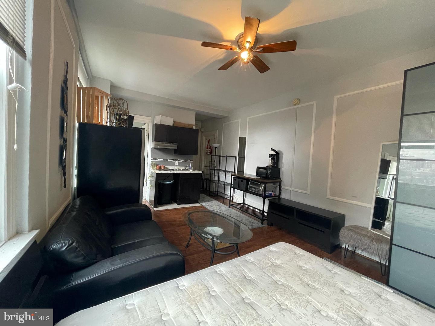 1324 Locust Street, Unit 727 Philadelphia, PA 19107 - Photo 5 of 7 a living room with furniture and a flat screen tv