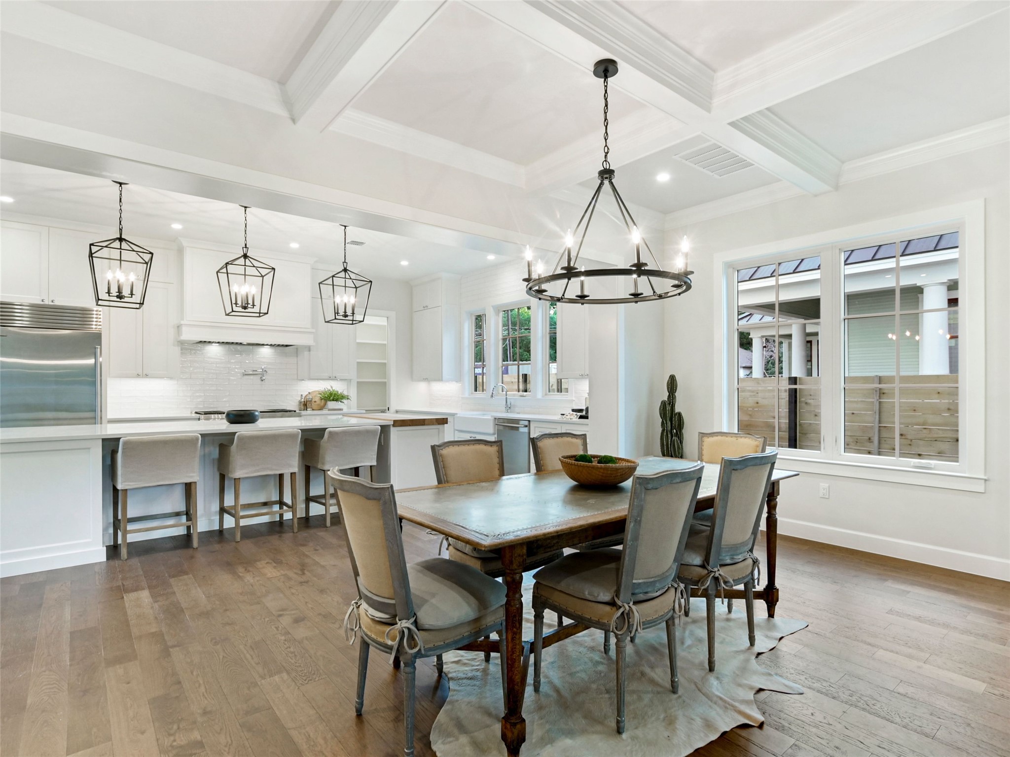 1603 Willow Street Austin, TX 78702 - Photo 7 of 30 a dining room with wooden floor a chandelier a wooden table and chairs