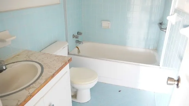 a bathroom with a granite countertop sink and a toilet