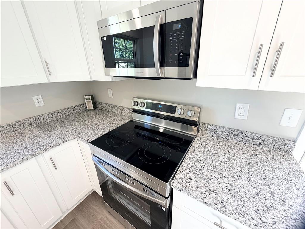 382 Arlington Lane Commerce, GA 30529 - Photo 13 of 43 a kitchen with wooden cabinets and a stove top oven