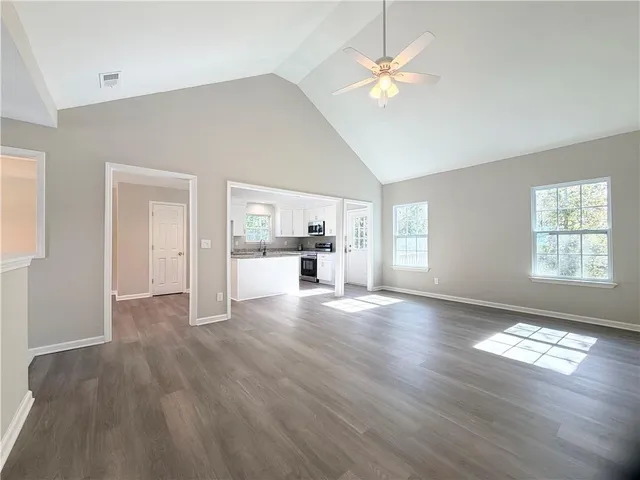 a view of empty room with windows and ceiling fan