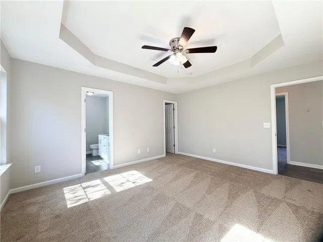 en empty room with windows and ceiling fan