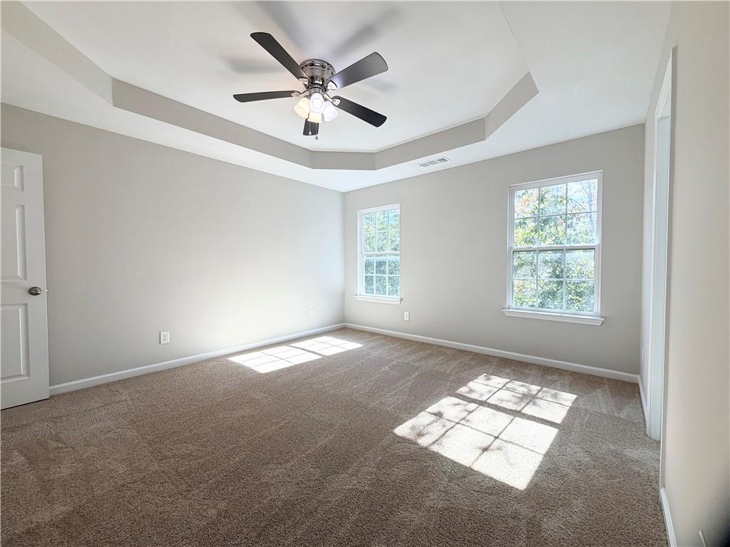 382 Arlington Lane Commerce, GA 30529 - Photo 19 of 43 en empty room with windows and ceiling fan