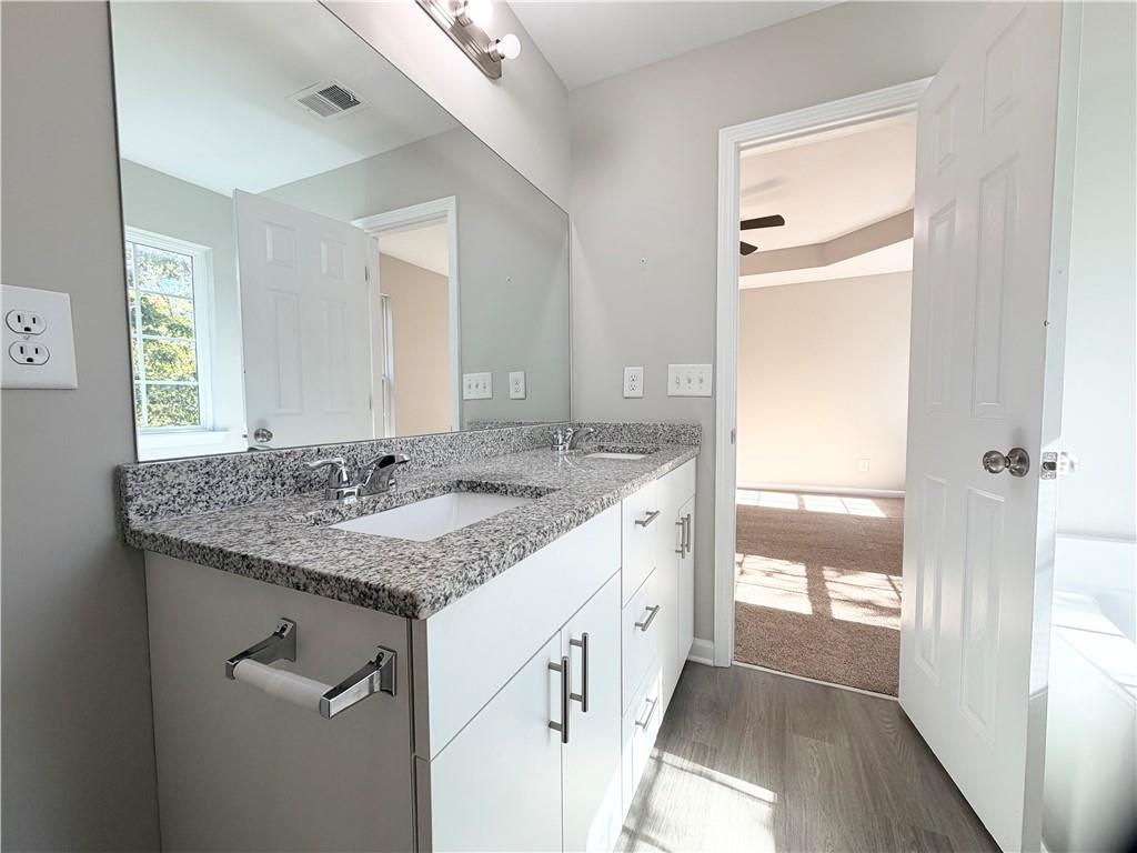 382 Arlington Lane Commerce, GA 30529 - Photo 23 of 43 a bathroom with a granite countertop sink and a mirror