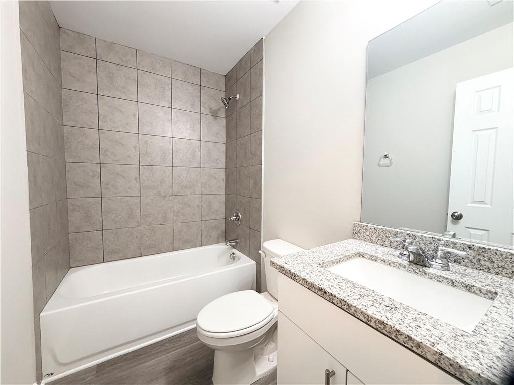 382 Arlington Lane Commerce, GA 30529 - Photo 26 of 43 a bathroom with a granite countertop sink toilet mirror and bathtub