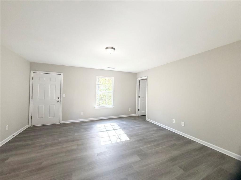 382 Arlington Lane Commerce, GA 30529 - Photo 31 of 43 a view of an empty room with wooden floor and a window