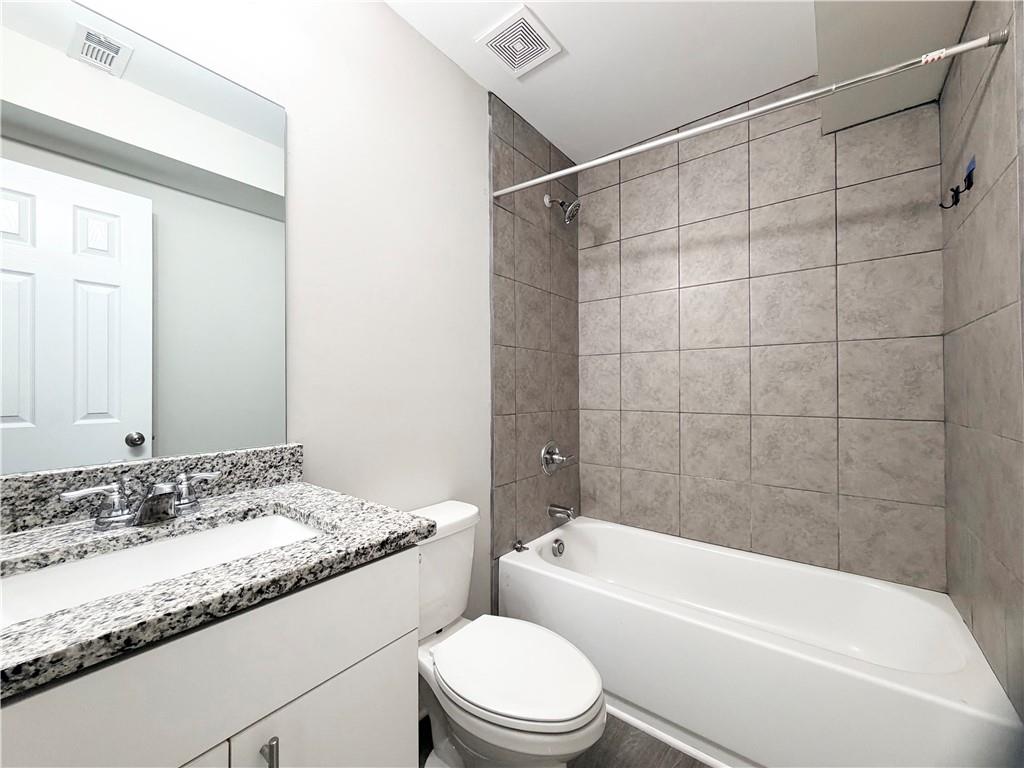 382 Arlington Lane Commerce, GA 30529 - Photo 34 of 43 a bathroom with a granite countertop bathtub shower sink vanity mirror and toilet
