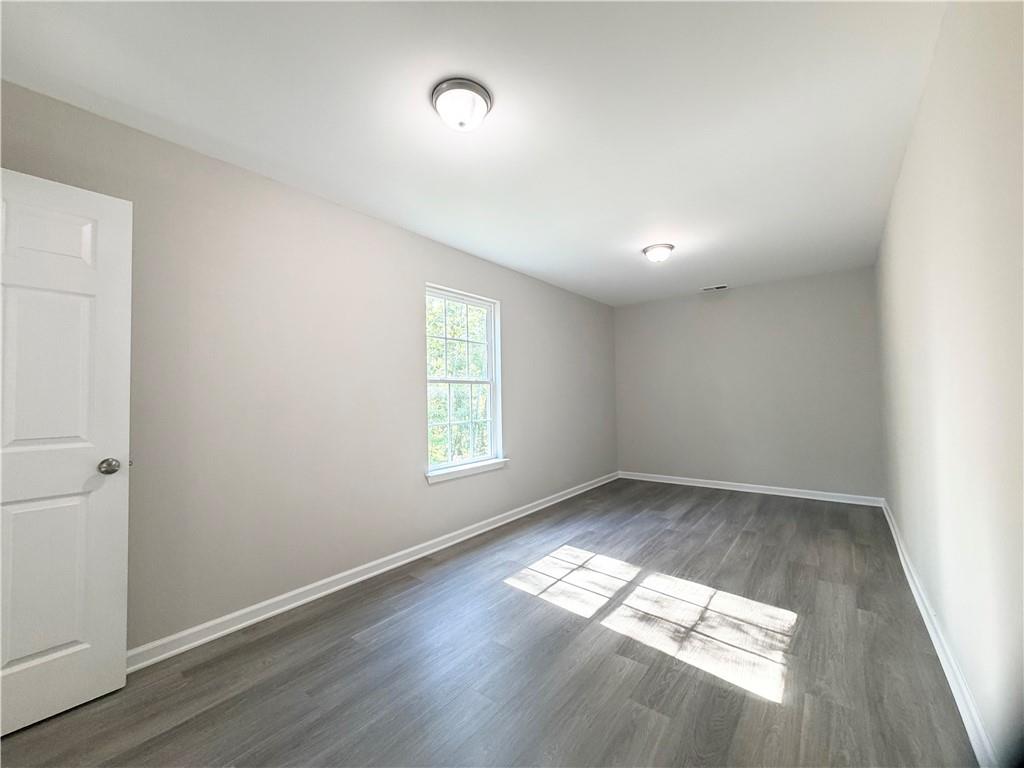 382 Arlington Lane Commerce, GA 30529 - Photo 39 of 43 an empty room with wooden floor and windows
