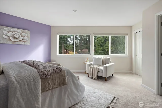 a bedroom with a bed and large window