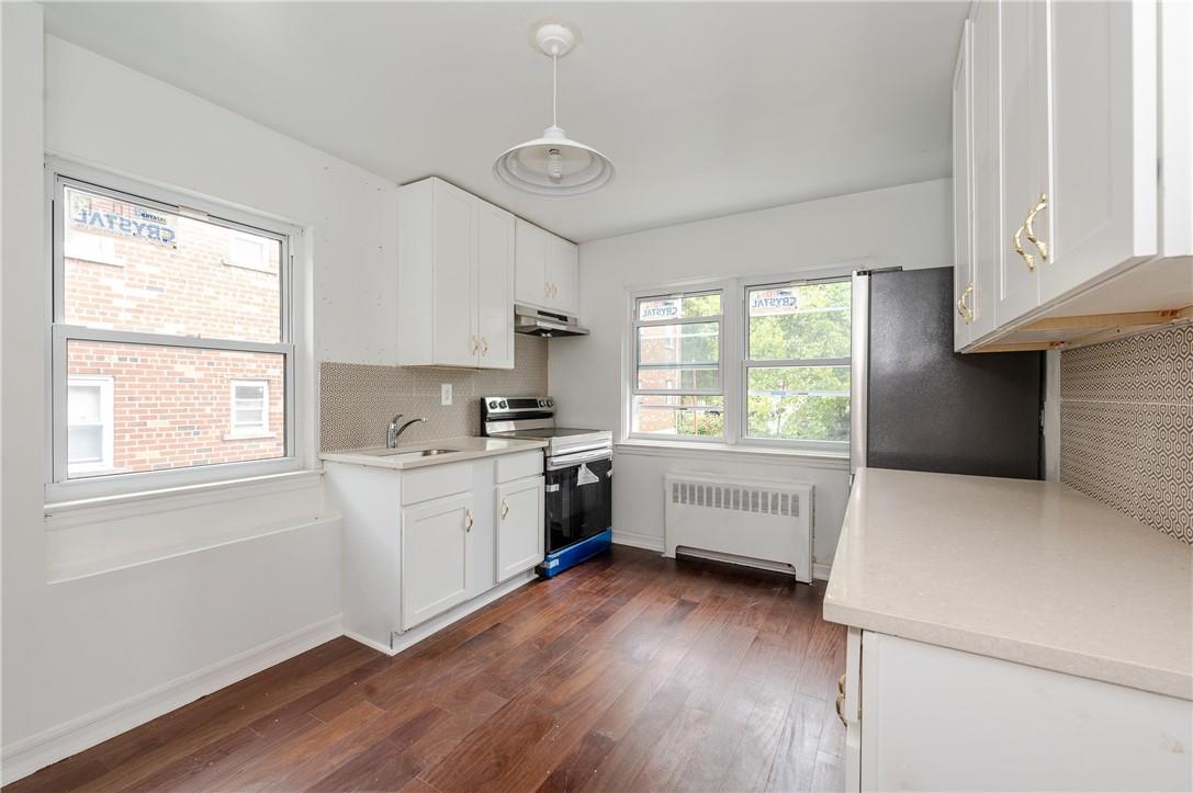 2855 Middletown Road Bronx, NY 10461 - Photo 9 of 19 a kitchen with a refrigerator wooden floor a sink and a window