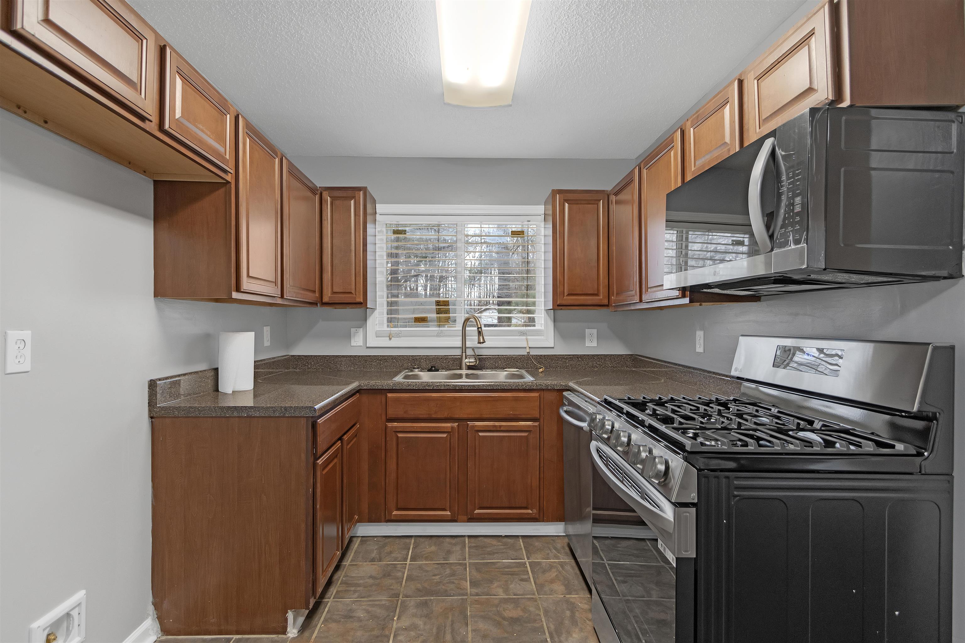 3324 William Tell Drive Memphis, TN 38127 - Photo 11 of 28 Kitchen featuring a textured ceiling, sink, and appliances with stainless steel finishes
