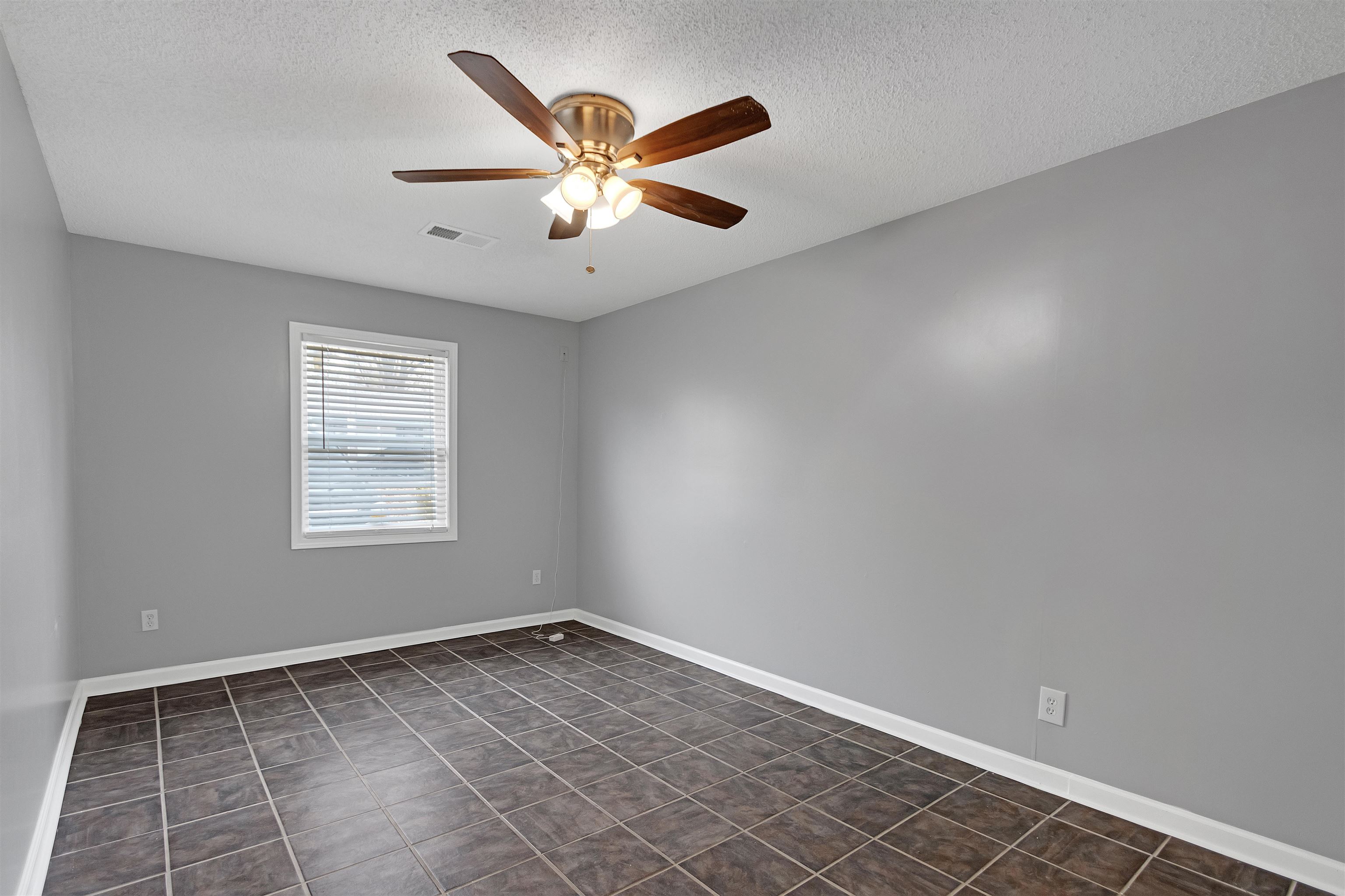 3324 William Tell Drive Memphis, TN 38127 - Photo 14 of 28 Unfurnished room with dark tile patterned flooring, ceiling fan, and a textured ceiling