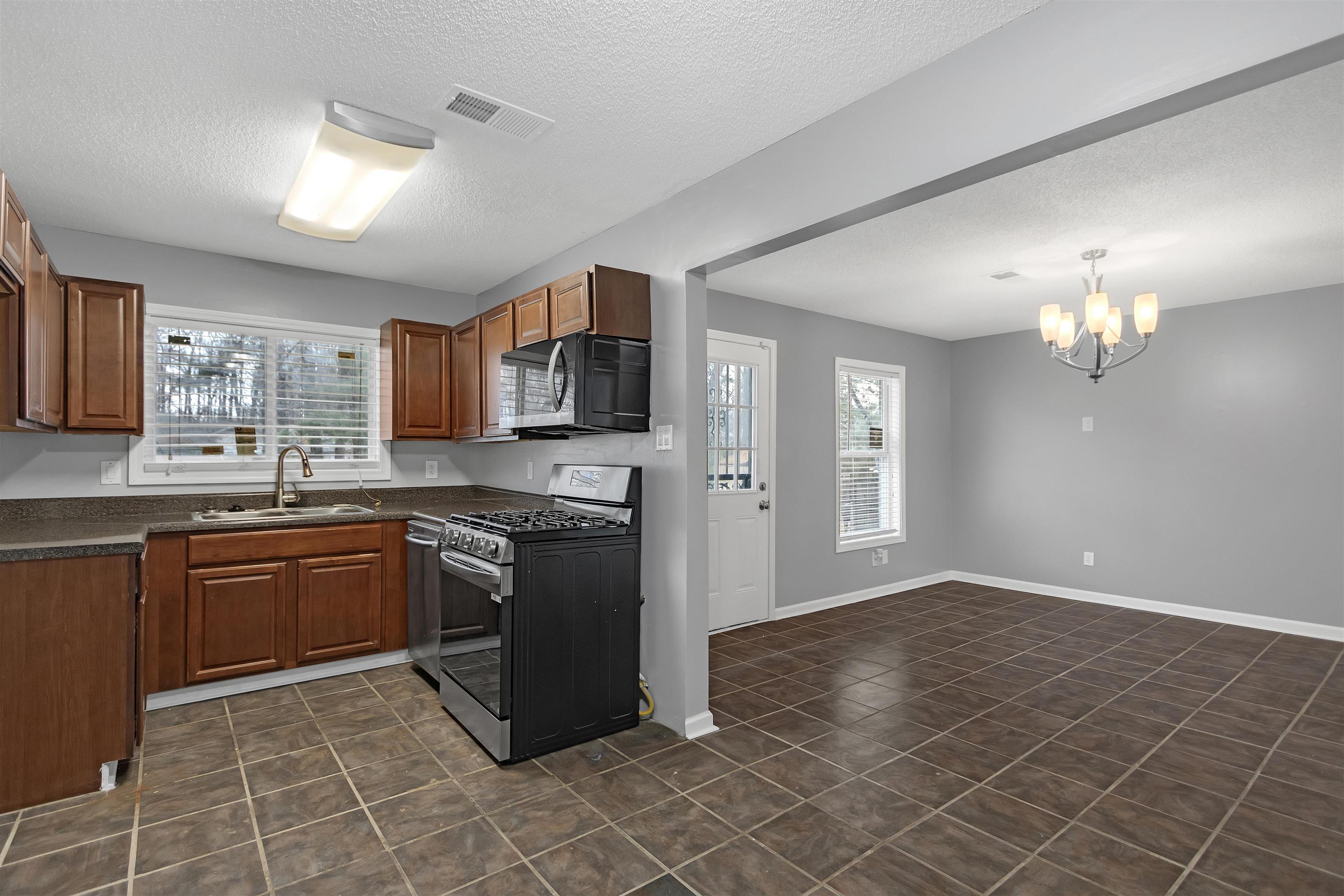 3324 William Tell Drive Memphis, TN 38127 - Photo 10 of 28 Kitchen with a textured ceiling, sink, a notable chandelier, and stainless steel gas range